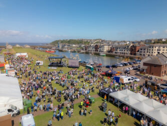 A photo of the taste of the sea festival with lots of people and stands on grass.